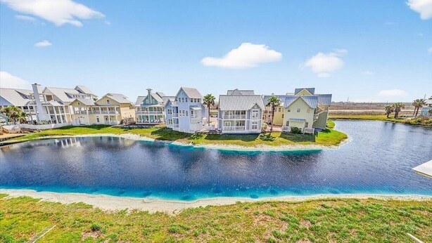 Une propriété située au bord de l’eau, comprenant plusieurs maisons, une piscine et offrant une vue dégagée sur l’eau.