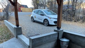 A white car parked in a gravel area with a concrete structure nearby. - Wild Horse Guesthouse, Downtown Durango (Durango)