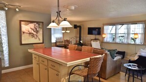 A spacious living area with a large island, a dining table, and a cozy seating arrangement. - Wild Horse Guesthouse, Downtown Durango (Durango)