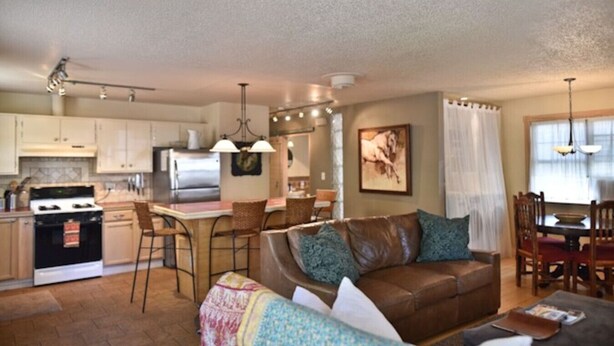 A compact living space with a kitchenette, a dining area, and a seating area with a sofa and chairs. - Wild Horse Guesthouse, Downtown Durango (Durango)