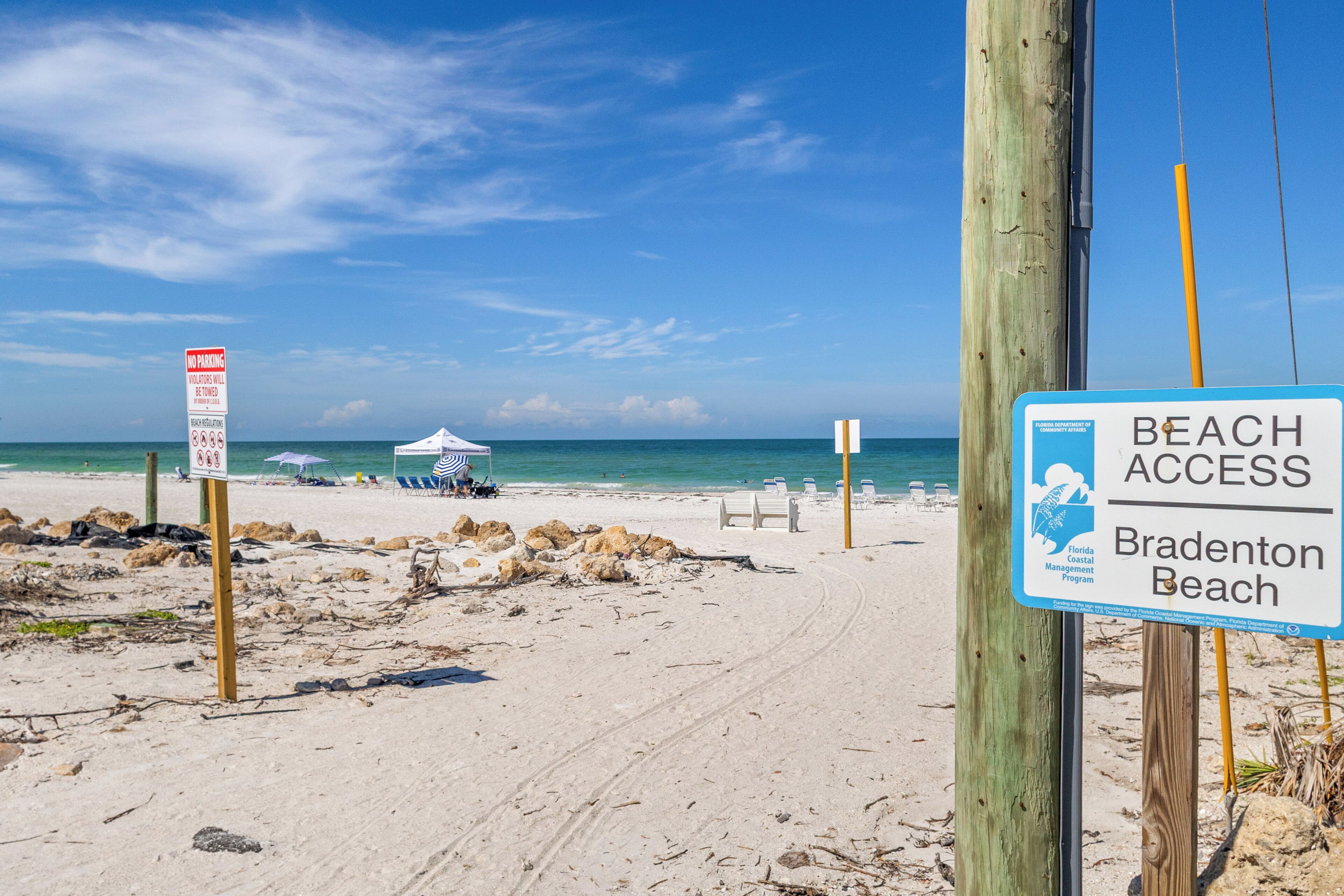 Una playa con un cartel que indica acceso a la playa de Bradenton.