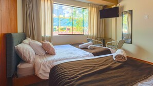 A hotel room with two beds, a TV, a small table, and a chair. - Hermoza House Bed & Breakfast (Cusco)