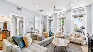 A spacious living room with a large sofa, a coffee table, and a dining area with a lamp. - Come stay with us at the Golden Hour! Spacious and relaxing 2 bed/2 bath cond (Port Aransas)