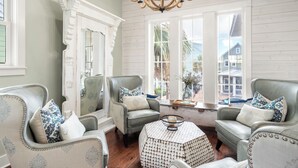 A room with two armchairs, a round table, and a large window with a view of the outside. - Pet-Friendly, Lakeside Home at Cinnamon Shore w/ Access to Pools & More (Port Aransas)