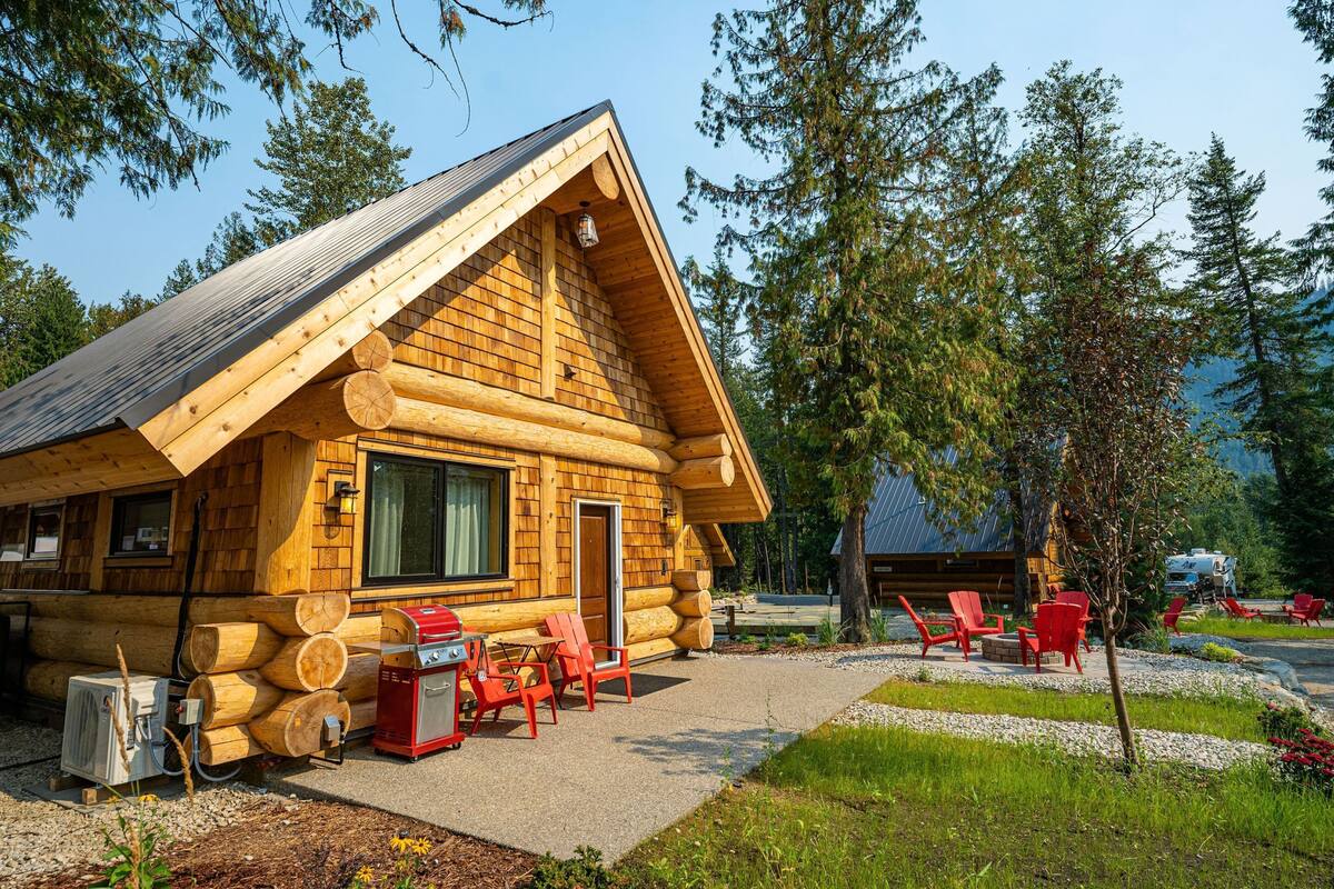 A log cabin with a patio area, outdoor seating, and a visible chimney.