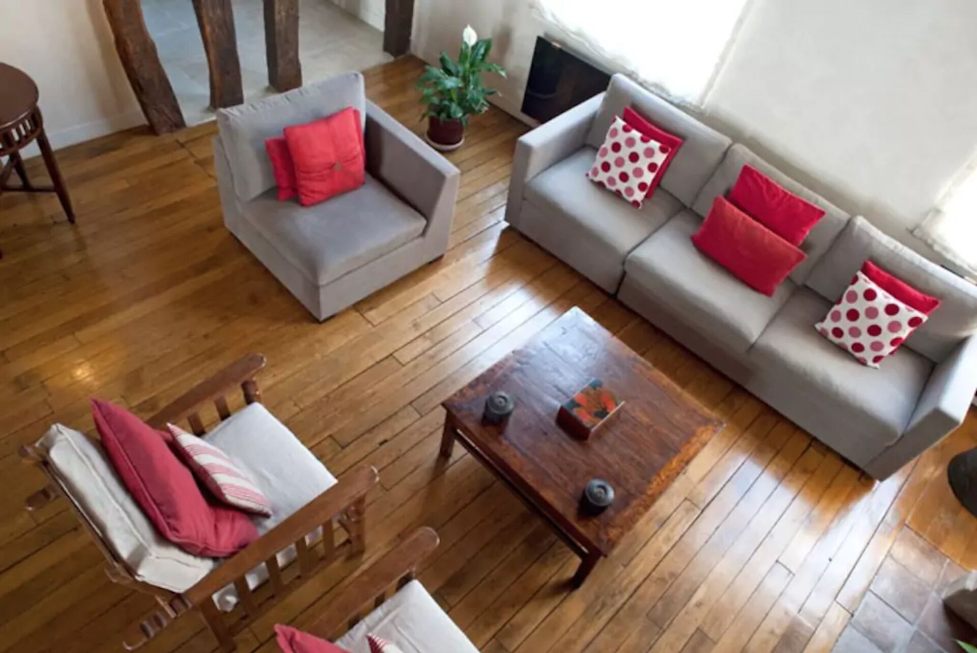Un salon avec un canapé gris, une table basse en bois et une chaise en bois.