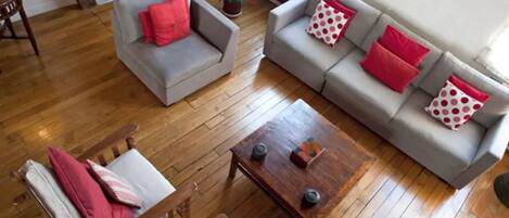 Un salon avec un canapé gris, une table basse en bois et une chaise en bois.