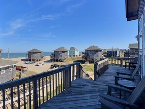 A wooden deck leading to beach houses with a view of the ocean. - Shell Castle Cottage- 4 Bdrm- Steps from beach- Community Pool & Spa (Buxton)
