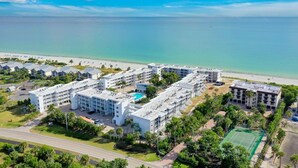 A resort with multiple buildings, a swimming pool, and a tennis court.