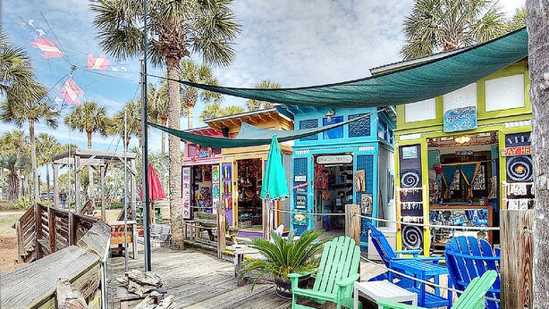 A wooden deck with green Adirondack chairs, a small table, and a tiki bar with colorful signage. - ☀️Community Pool-PRIME 30A Location-Topsail Village 422☀️ (Santa Rosa Beach)