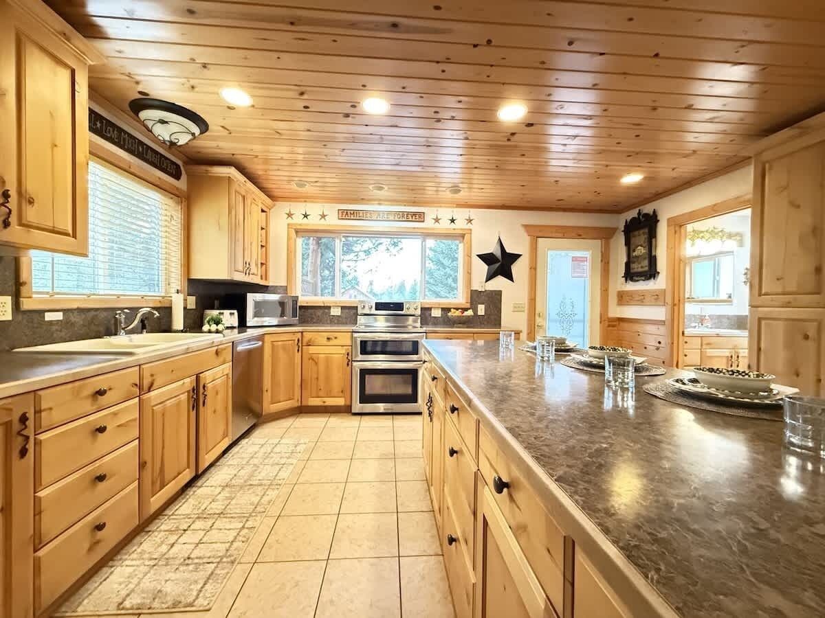 Un'ampia cucina con mobili in legno, un piano di lavoro in granito e una grande isola.