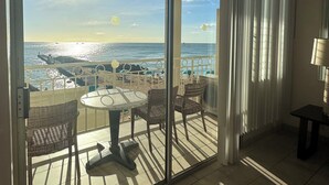A balcony with a view of the ocean, featuring a table and chairs. - Direct Oceanfront Waikiki!  Parking at Waikiki Shore included! (Honolulu)