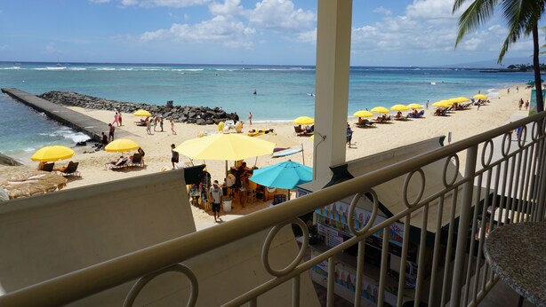 A beach with umbrellas and lounge chairs, a pier, and a view of the ocean. - Direct Oceanfront Waikiki!  Parking at Waikiki Shore included! (Honolulu)