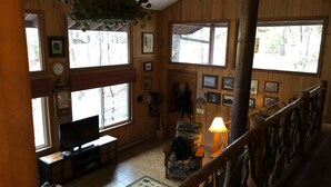 A wooden interior with a TV, seating, and a staircase. - Enjoy 'Treetops' in the North Ga Mountains.  Now with Wifi! (Rabun Gap)