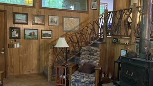 A wooden interior with a staircase, a patterned rug, and a fireplace. - Enjoy 'Treetops' in the North Ga Mountains.  Now with Wifi! (Rabun Gap)