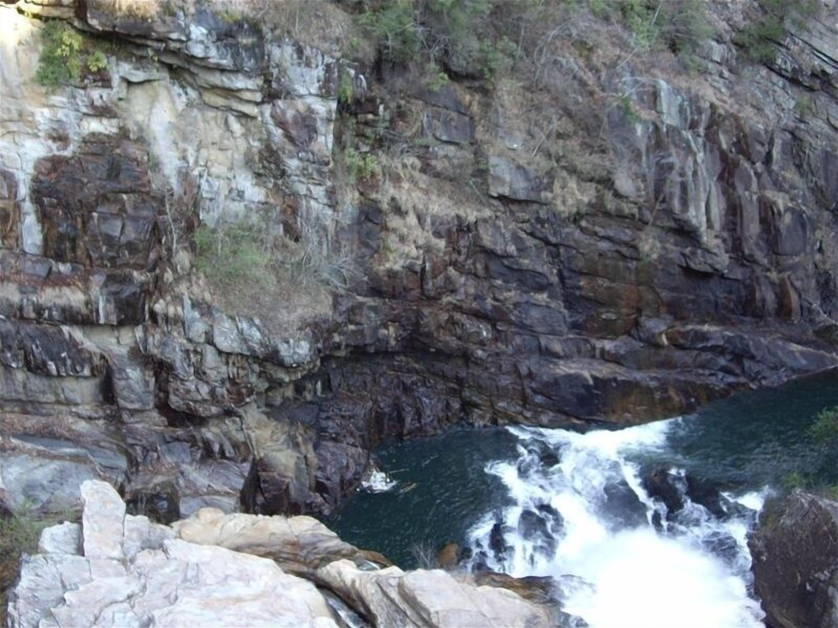 Un acantilado rocoso con una cascada.