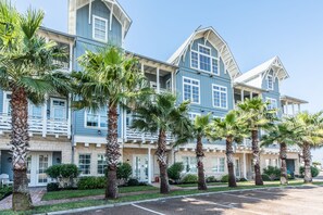 A multi-story hotel with a blue and white exterior, palm trees in the front, and a clear sky. - 1st-Fl Condo w/ Beachy Fun Style+Access to All Cinnamon Shore Amenities! (Port Aransas)