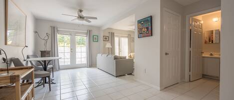 A spacious living area with a dining table, sofa, and a ceiling fan.