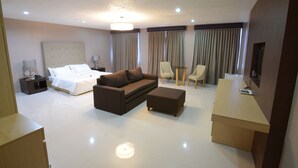 Ein Hotelzimmer mit Bett, Sofa, Schreibtisch und Stuhl.