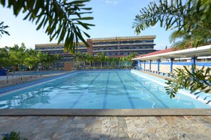 Una piscina con agua cristalina, rodeada de baldosas de piedra, y un edificio con la inscripción "Northwestern University" al fondo.