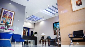 Eine moderne Lobby mit Empfangsschalter, Sitzgelegenheiten und Kunstwerken an den Wänden.