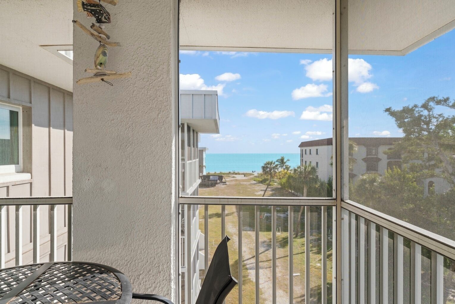 Ein Balkon mit Blick auf den Ozean und ein Gebäude gegenüber.
