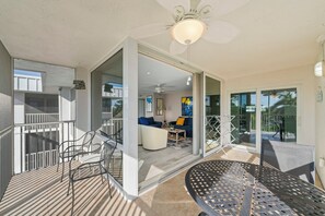 A modern apartment with a balcony, a dining area, and a living room with a sofa and a coffee table.