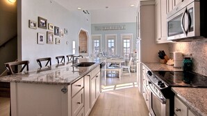 A spacious kitchen with a central island, stainless steel appliances, and a view to the dining area. - Spacious, 2-Story Condo w/ Lake Views at Cinnamon Shore+Resort Amenities! (Port Aransas)