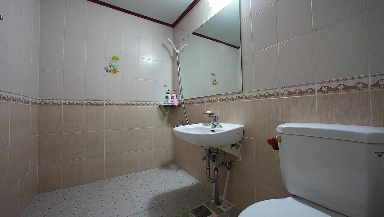 A bathroom with a toilet, sink, and shower.