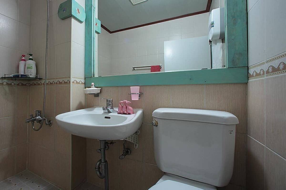 Ein Badezimmer mit einem weißen Waschbecken, einer Toilette und einem Spiegel über dem Waschbecken.