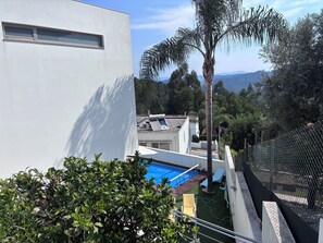 A residential area with a swimming pool, a white building, and a view of the surrounding landscape. - Luxury design villa with private heated pool, near the city of Porto! (Sanguedo)