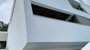 A modern building with a white facade, a visible window, and a brown lower section. - Luxury design villa with private heated pool, near the city of Porto! (Sanguedo)