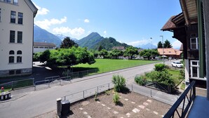 Blick auf eine Stadt mit einer Straße, Gebäuden und Bergen im Hintergrund.