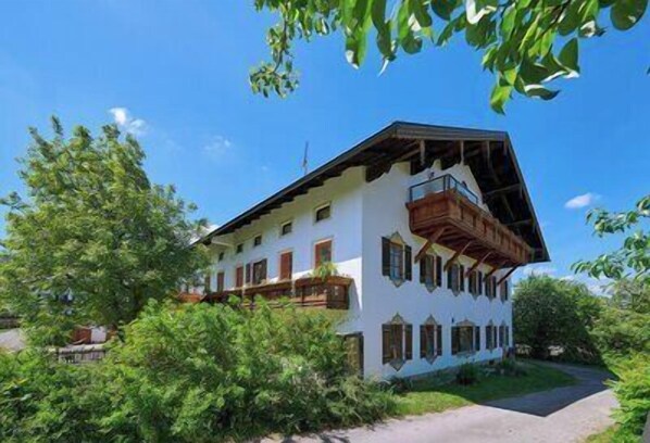 A two-story building with a balcony and a sloped roof.