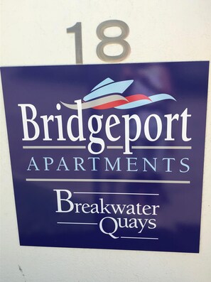 A sign for Bridgeport Apartments in Breakwater Quays, featuring a number '18' above.