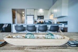 Un vassoio di legno con uova decorative e un bicchiere su un tavolo rustico in una cucina moderna.