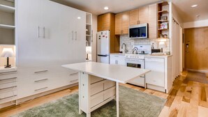 Een moderne keuken met witte kasten, een centraal eiland en ingebouwde apparatuur.