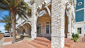 A stone building with a sign reading "TIKI JAYS" and a staircase leading to the entrance. - Beautiful, 3rd-Fl, Pet-Friendly Condo@Cinnamon Shore w/ Easy Amenity Access! (Port Aransas)