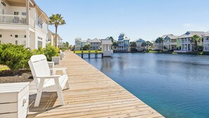 A wooden boardwalk leading to a canal with waterfront buildings. - Beautiful, 3rd-Fl, Pet-Friendly Condo@Cinnamon Shore w/ Easy Amenity Access! (Port Aransas)