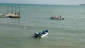 A calm body of water with several boats, a dock, and a pier. - Nestled on a hill with Mountain Views (Bo Cataño, Humacao)