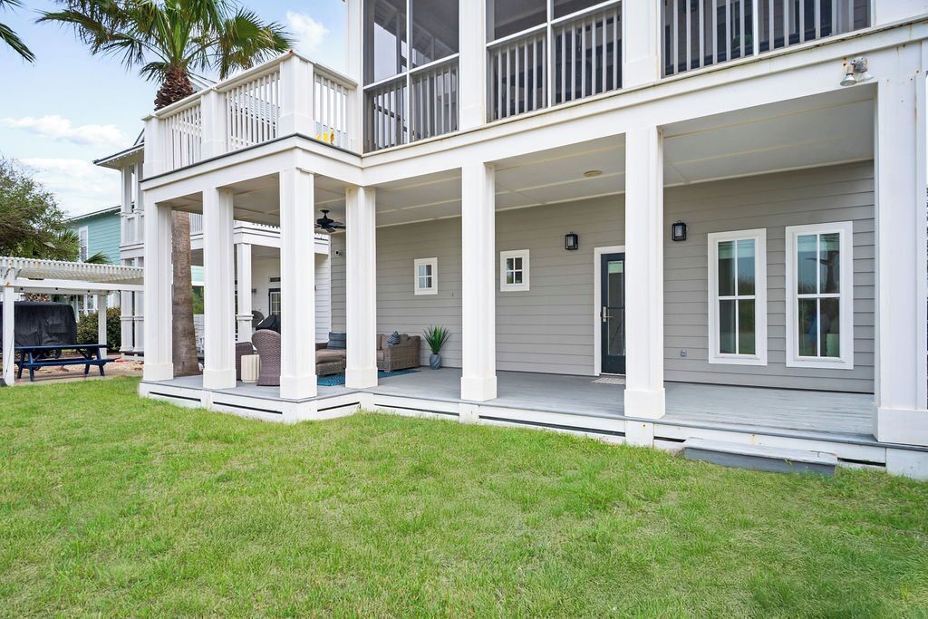 A two-story house with a covered porch, a patio, and a swimming pool.