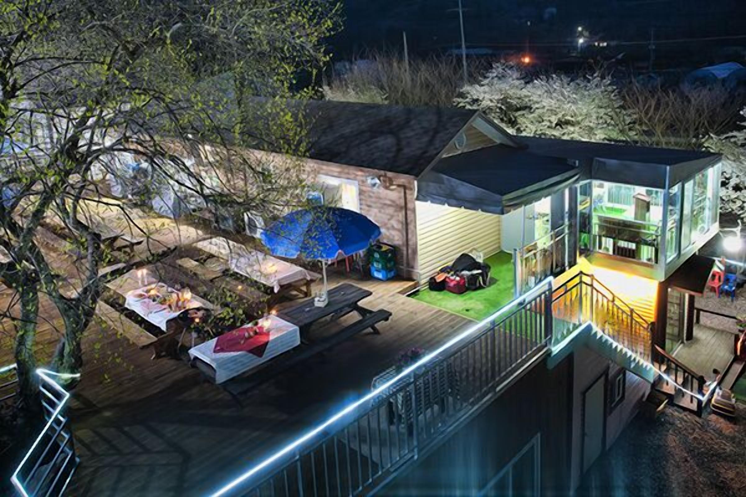 Una casa moderna con una terraza, un comedor y un nivel superior con paredes de vidrio.