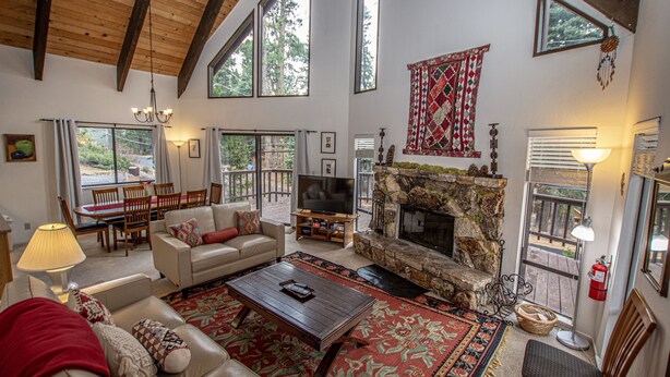 A spacious living room with a fireplace, large windows, and a cozy seating area.