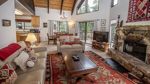 A spacious living room with a fireplace, a television, and a cozy seating area.