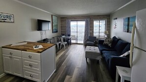 Un espacio habitable pequeño con kitchenette, comedor y sofá.