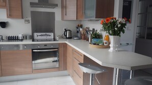 Eine moderne Küche mit Holzausstattung, Edelstahlgeräten und einer weißen Arbeitsplatte.
