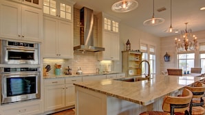 A kitchen with white cabinets, stainless steel appliances, a large island with bar stools, and pendant lighting. - Private Cinnamon Shore Home 2-Min. Walk from Pool w/ More Amenities Nearby (Port Aransas)