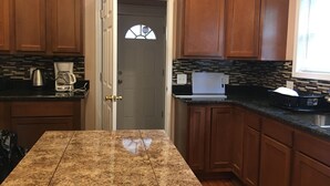 A kitchen with wooden cabinets, a granite countertop, a coffee maker, and a toaster. - Newly updated house close to the Clinic,UH, Case in Cleveland Hts. (Cleveland Heights)