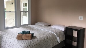 A bedroom with a bed, pillows, a bedside table, and a window. - Newly updated house close to the Clinic,UH, Case in Cleveland Hts. (Cleveland Heights)