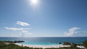 Una playa con cielos despejados y aguas tranquilas.